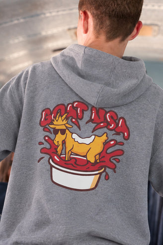 A person viewed from behind wearing a heather gray hoodie with a large back graphic showing a chicken nugget goat in ketchup under the words “GOAT USA”.