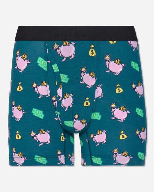 A pair of men's boxer briefs by GOAT USA, featuring a teal green background with a repeating pattern of pink pigs wearing gold crowns and holding yellow money bags, along with green dollar bill graphics. The waistband is solid black.