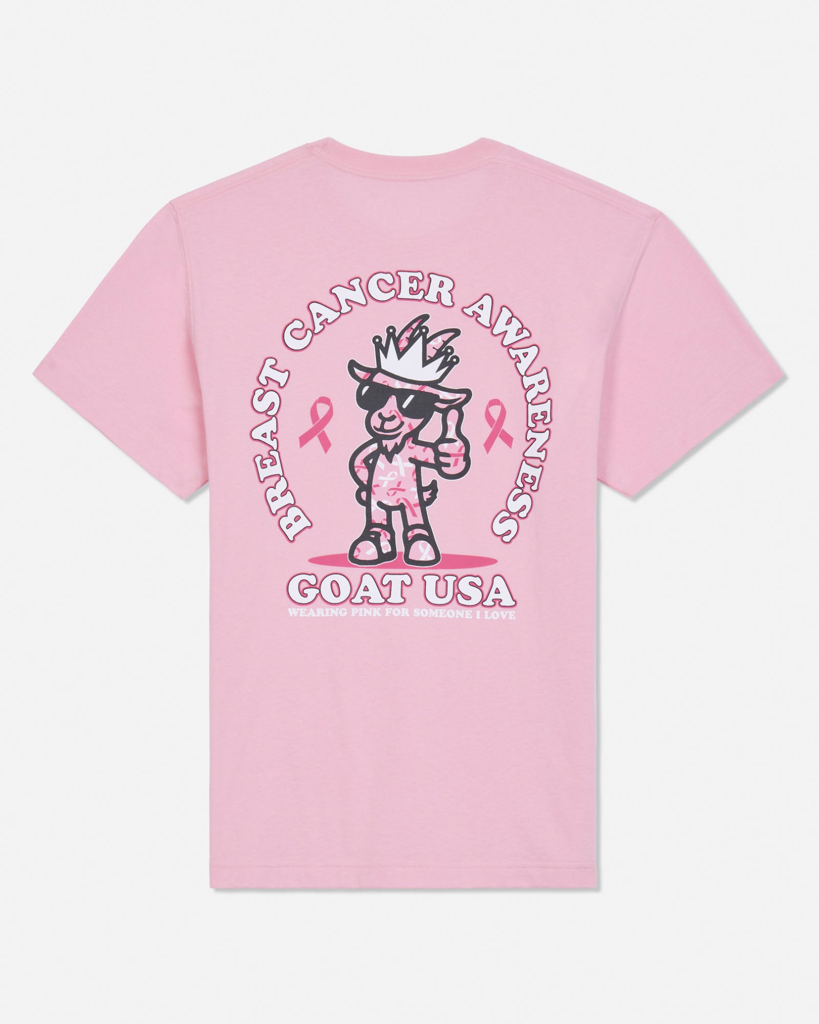 A light pink short-sleeve t-shirt shown from the back, featuring a large graphic print of a cartoon goat wearing sunglasses and a hat, surrounded by the text 'BREAST CANCER AWARENESS' and 'GOAT USA' with pink ribbons.