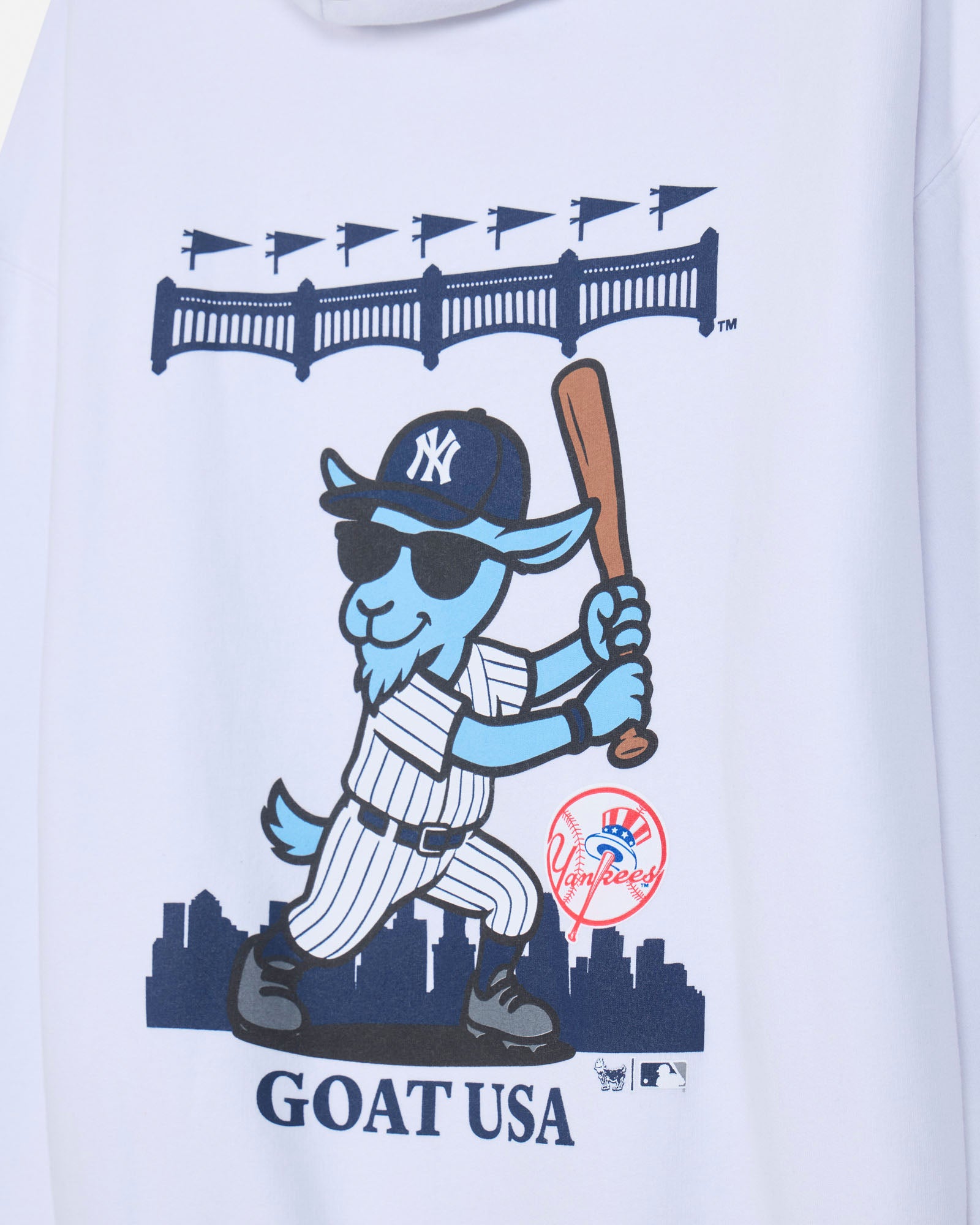 Close-up of blue baseball player goat mascot in a New York Yankees uniform on a white hoodie