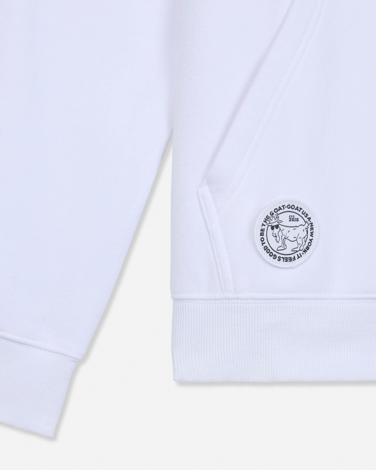 Close-up of embroidered patch on pocket of white hoodie