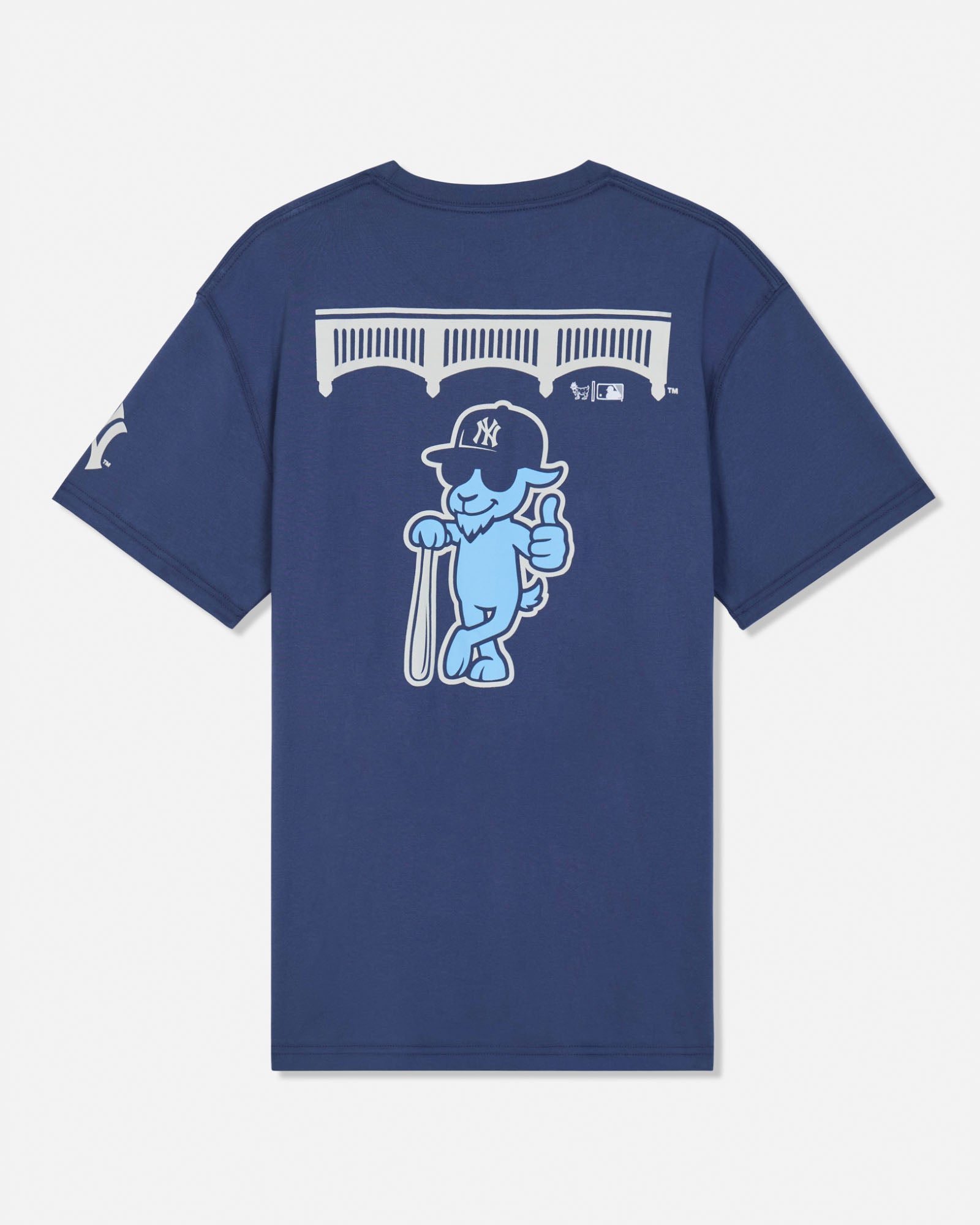 A navy blue short-sleeve t-shirt shown from the back, featuring a large graphic of a light blue cartoon goat wearing a New York Yankees cap and holding a bat, with a white bridge graphic above.