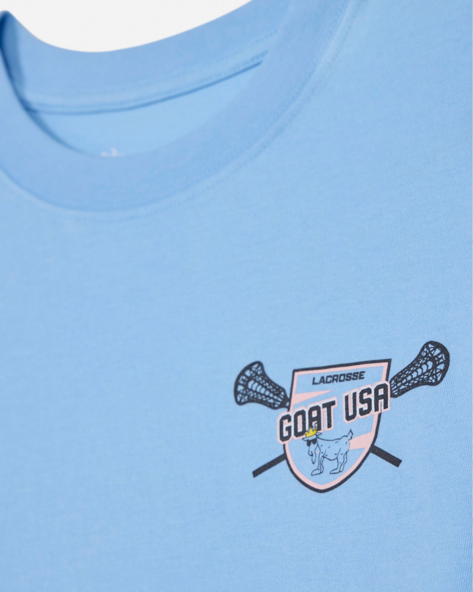 Close-up of blue crop top with lacrosse goat left-chest logo