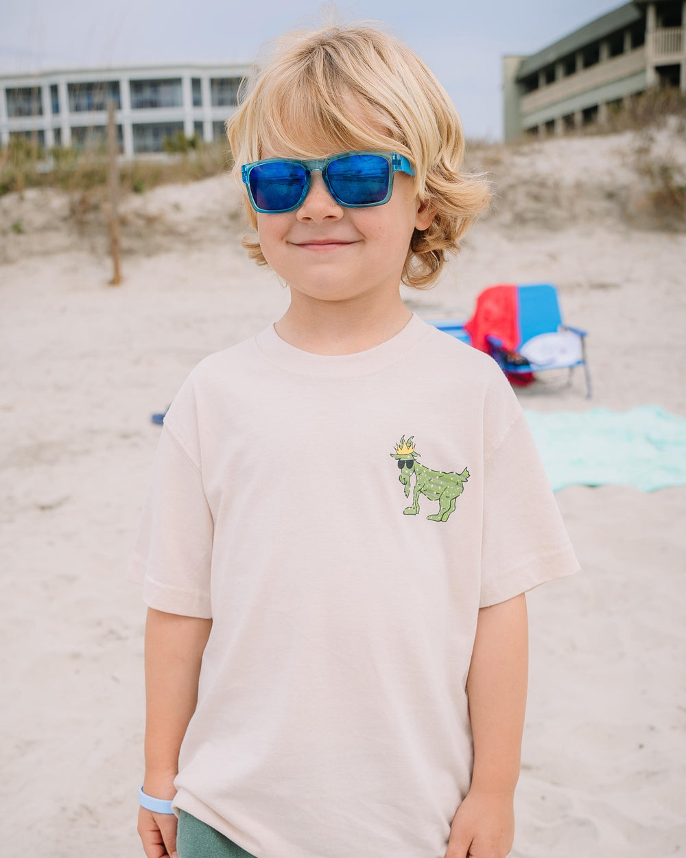 Kid with sunglasses smiling on beach