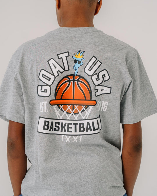 Kid wearing gray t-shirt with design that reads "GOAT USA Basketball"#color_gray
