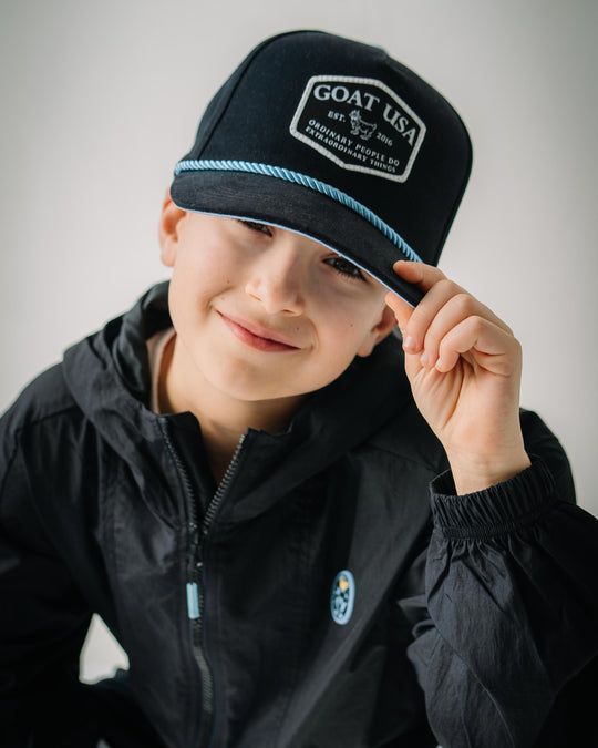 Kid wearing black snapback with blue rope and embroidered patch#color_black