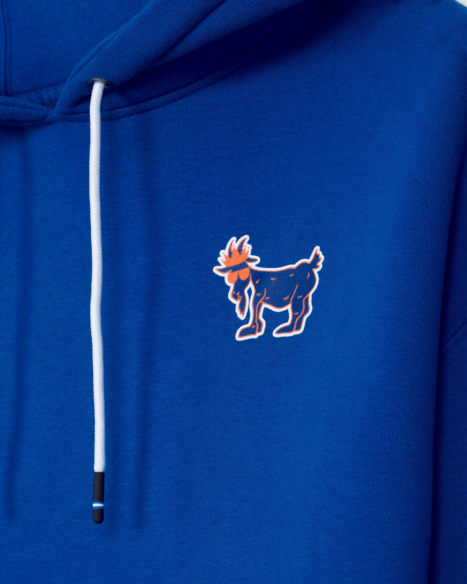 Close-up of a royal blue hoodie featuring a white drawstring and a small printed goat graphic on the chest.
