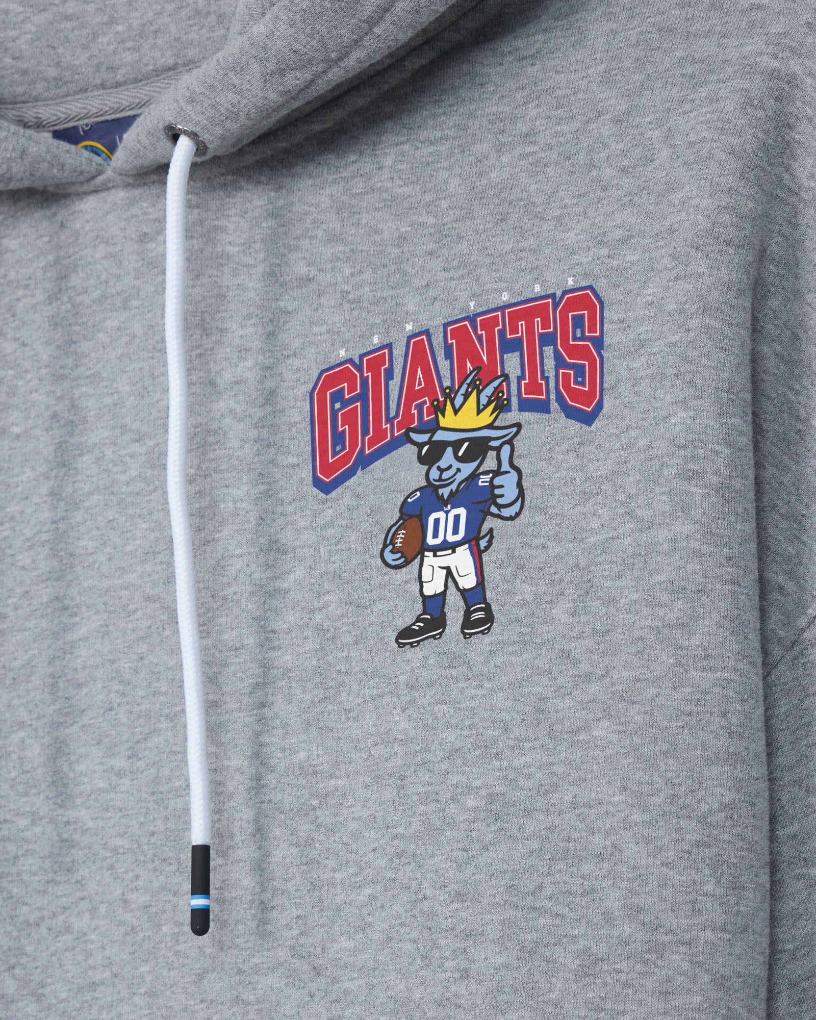 Close-up of a heather gray hoodie featuring a white drawstring and a colorful chest graphic with the word 'GIANTS' in red and blue, above a cartoon blue animal mascot wearing a gold crown and football uniform.