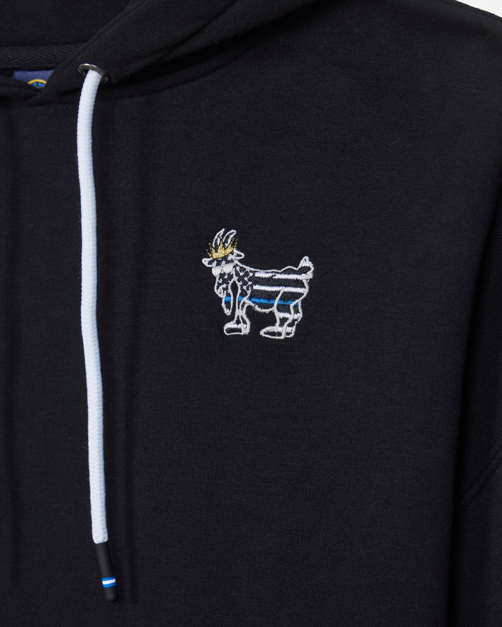 Close-up of a black hoodie featuring a white drawstring and a small embroidered goat mascot logo on the left chest, with blue and gold details.