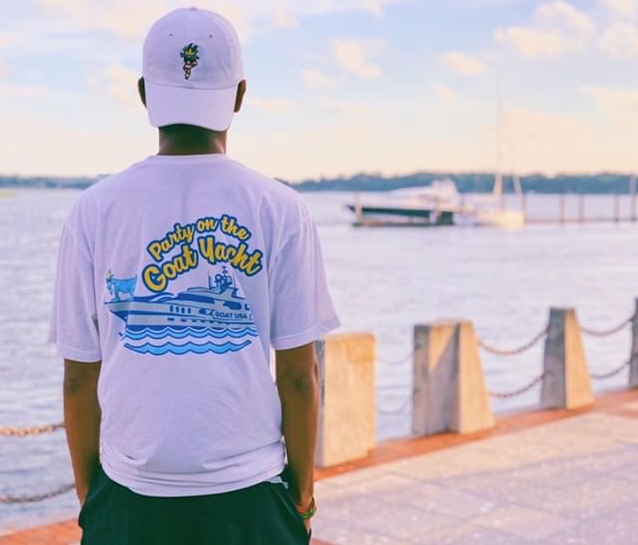 GOAT USA customer wearing a Party on the Goat Yacht tee by the water
