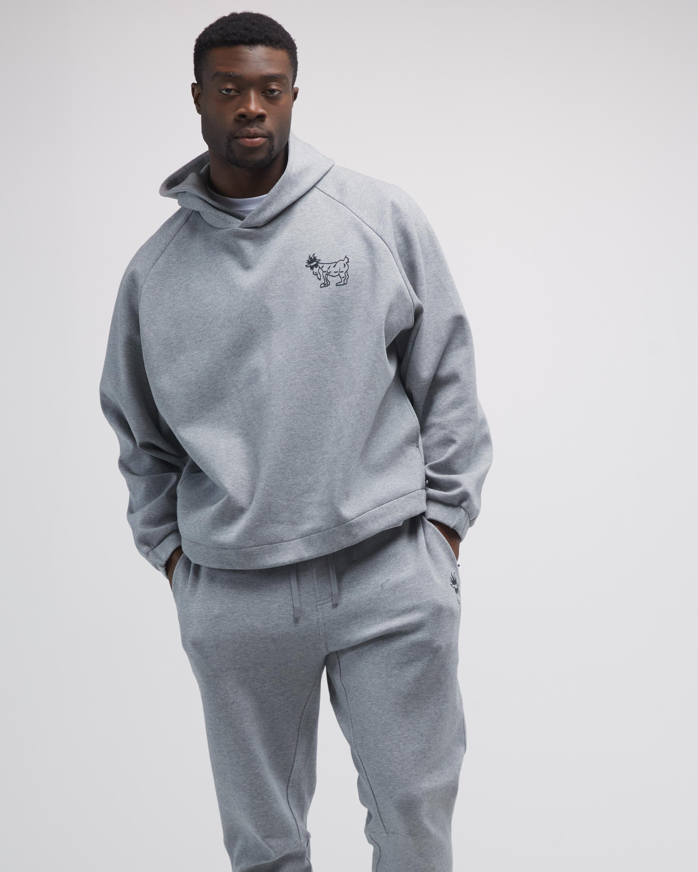 Man wearing a gray hoodie and pants set on a light gray background#color_gray