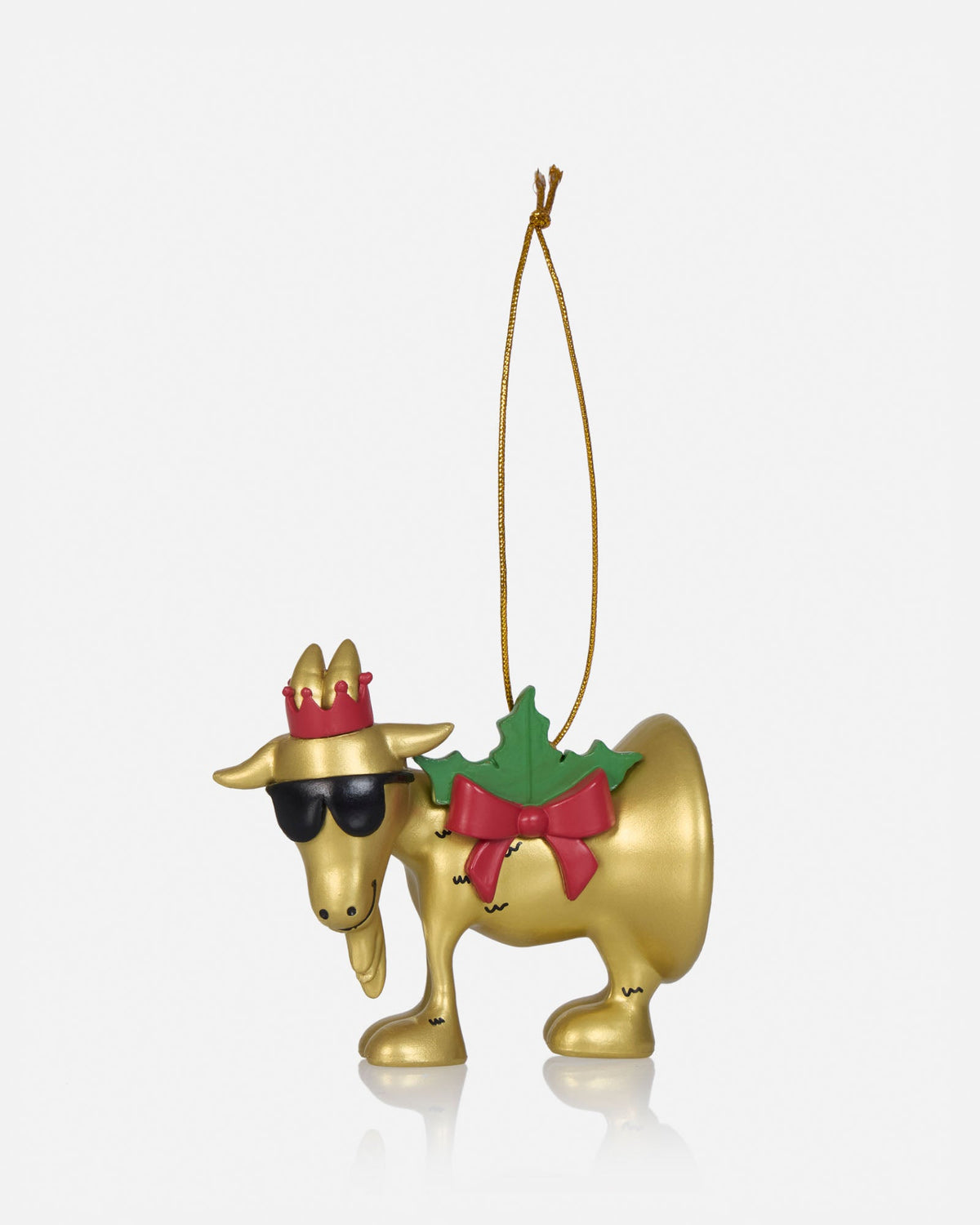 A gold Christmas ornament shaped like a moose wearing a red crown, black sunglasses, a green holly wreath with a red bow, and a gold hanging string, shown on a light gray background.