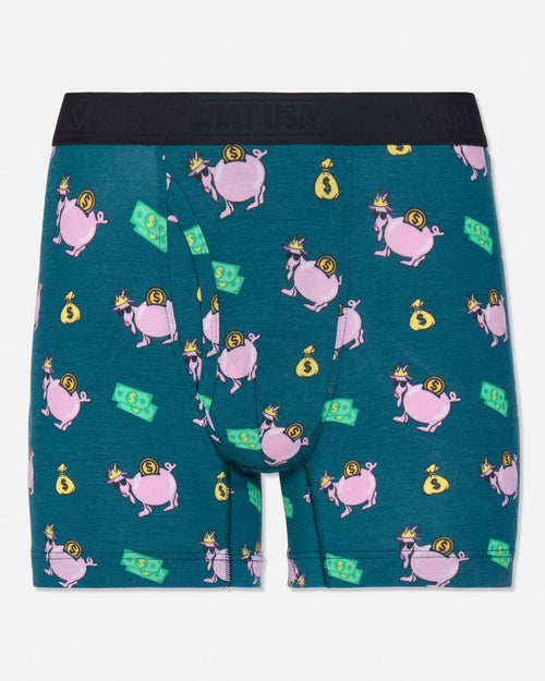 A pair of men's boxer briefs by GOAT USA, featuring a teal green background with a repeating pattern of pink pigs wearing gold crowns and holding yellow money bags, along with green dollar bill graphics. The waistband is solid black.