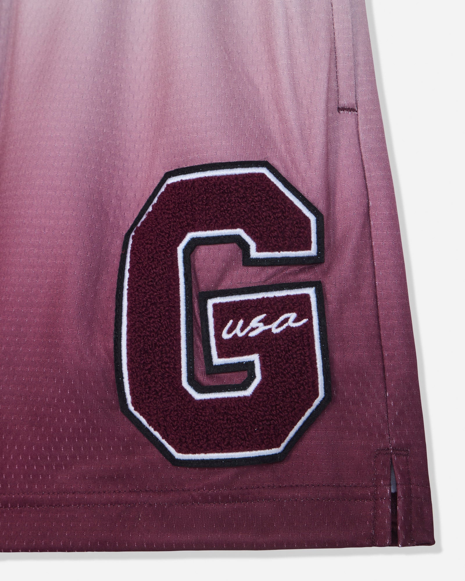Close-up of 'G'-patch on maroon fade mesh shorts#color_windsor-wine