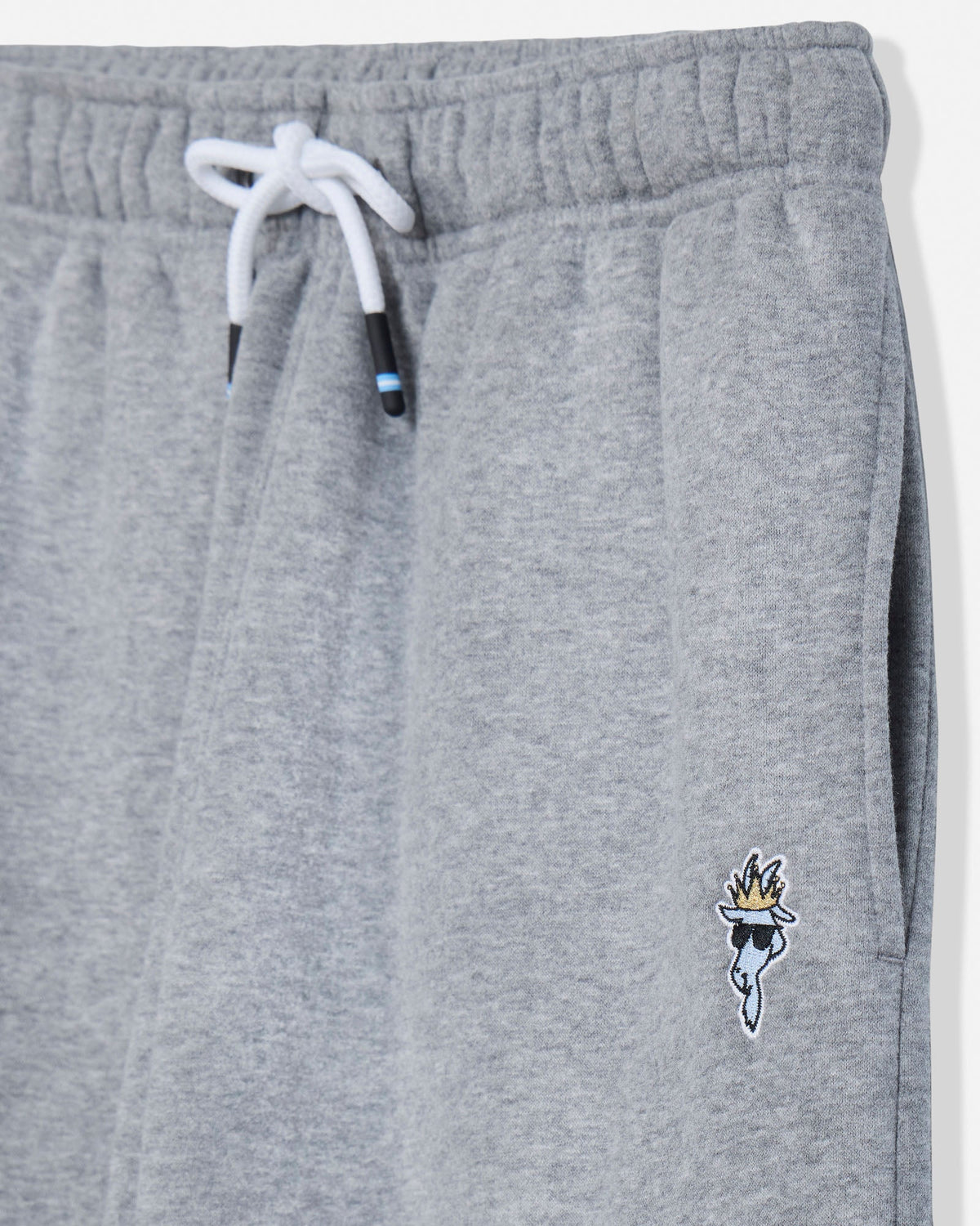 Close-up of heather gray sweatpants with a white drawstring and a small embroidered mascot logo near the lower left leg.