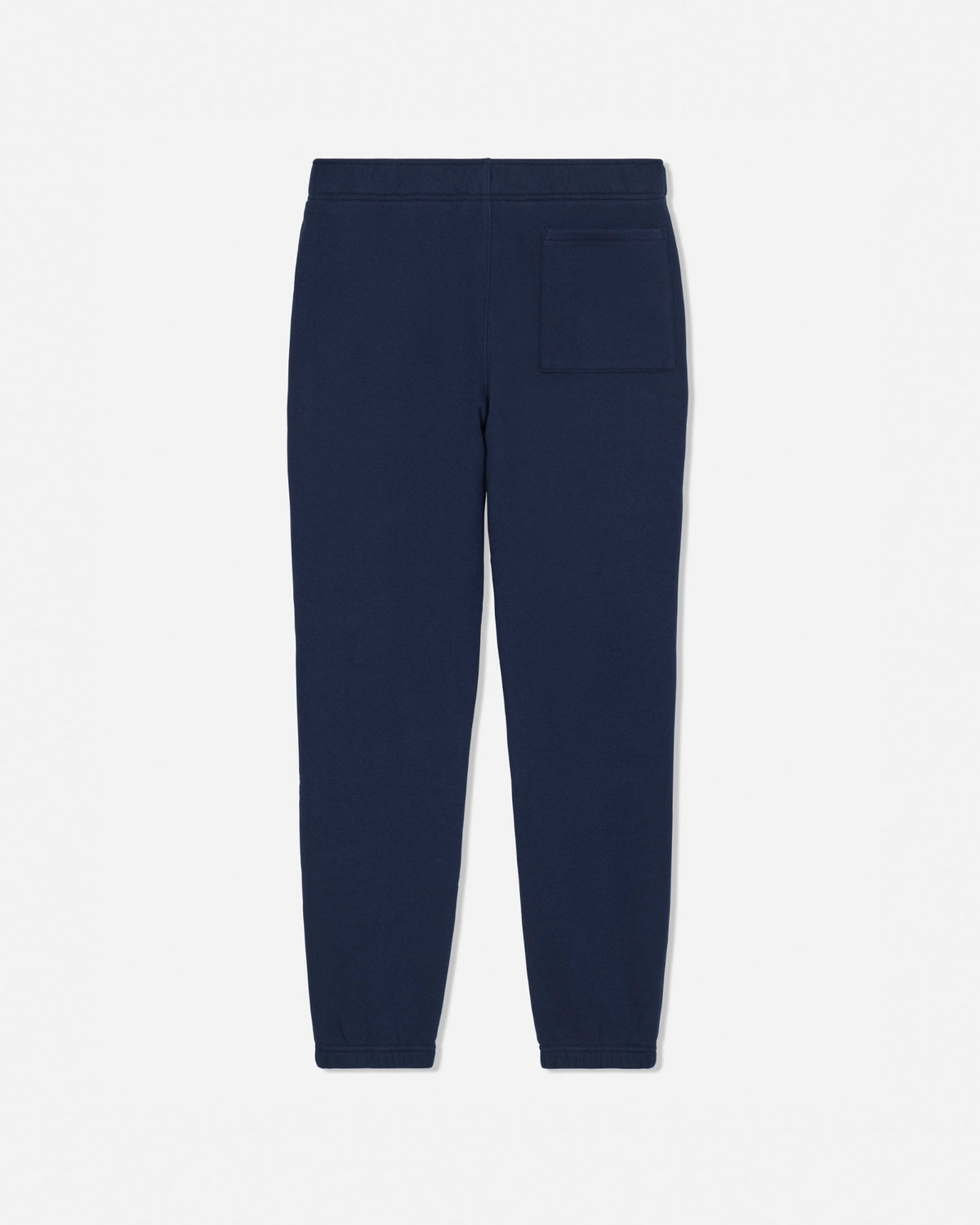 A pair of navy blue sweatpants shown from the back, featuring a flat back waistband and a single patch pocket on the right side, set against a plain light gray background.