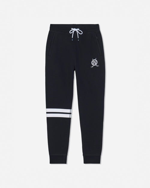 Black sweatpants with a white drawstring, a small white crest logo on the left thigh, and two horizontal white stripes near the lower left leg, shown against a light gray background.