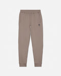 A pair of beige sweatpants with an elastic waistband, side pockets, and a small embroidered rose logo on the left thigh, shown against a plain light gray background.