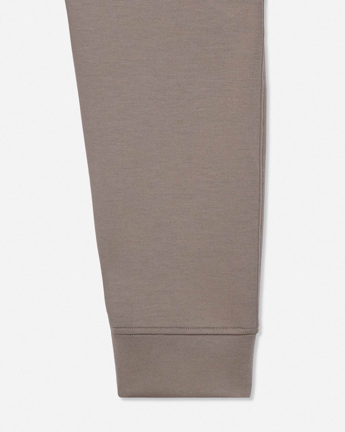 A close-up of a taupe-brown fabric leg, showing the texture and color of the fabric on a plain white background.