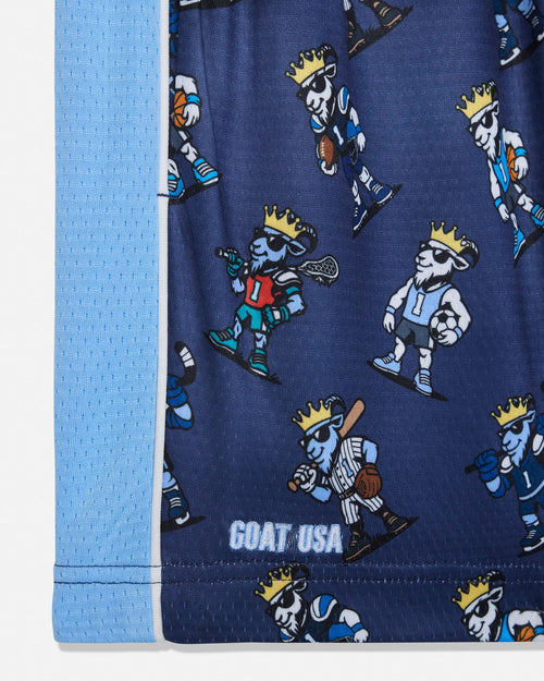 Close-up of a navy blue athletic mesh garment with a repeating cartoon goat mascot print in white, blue, yellow, and red, plus a light blue mesh side panel and visible GOAT USA text near the hem.