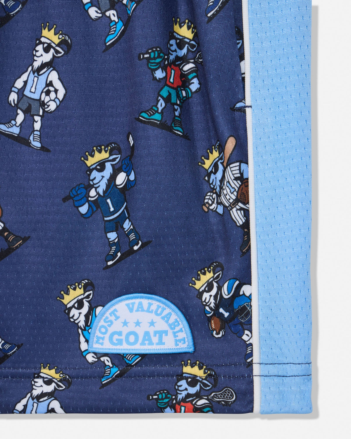 Close-up of a blue athletic fabric product with an allover cartoon goat player print and a light blue mesh side panel. A sewn patch reads 'MOST VALUABLE GOAT'.