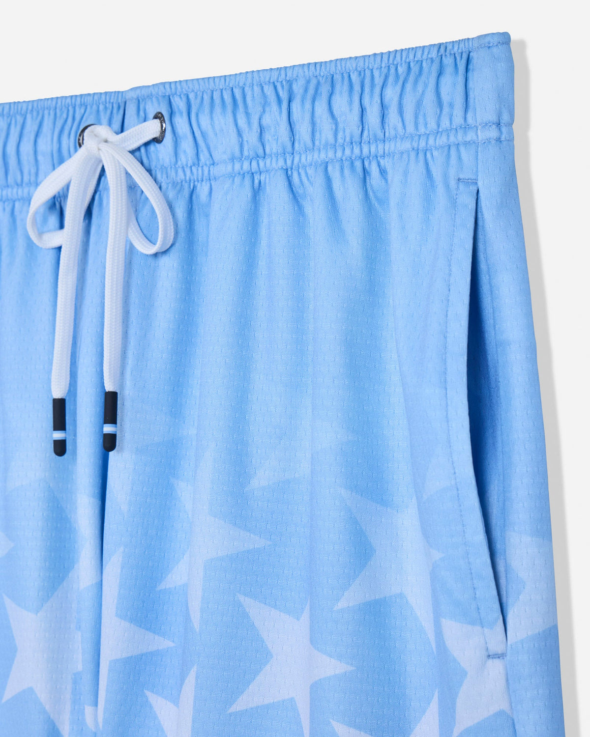 Close-up of pocket of carolina blue mesh shorts with a star pattern