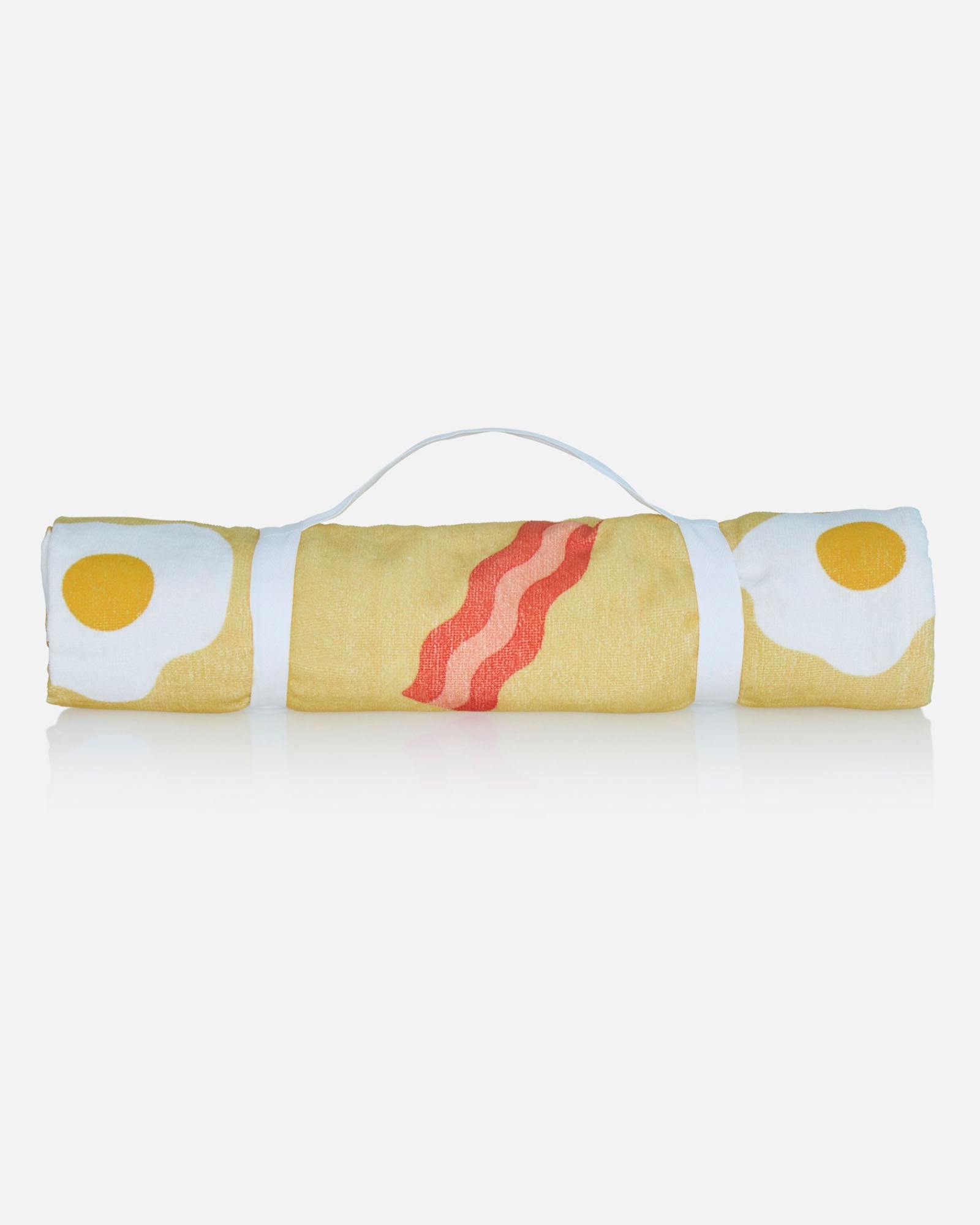 Rolled up beach towel with bacon and eggs pattern