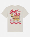 Beige t-shirt with a cartoon goat wearing sunglasses and a crown, labeled 'GOAT USA', on a white background.