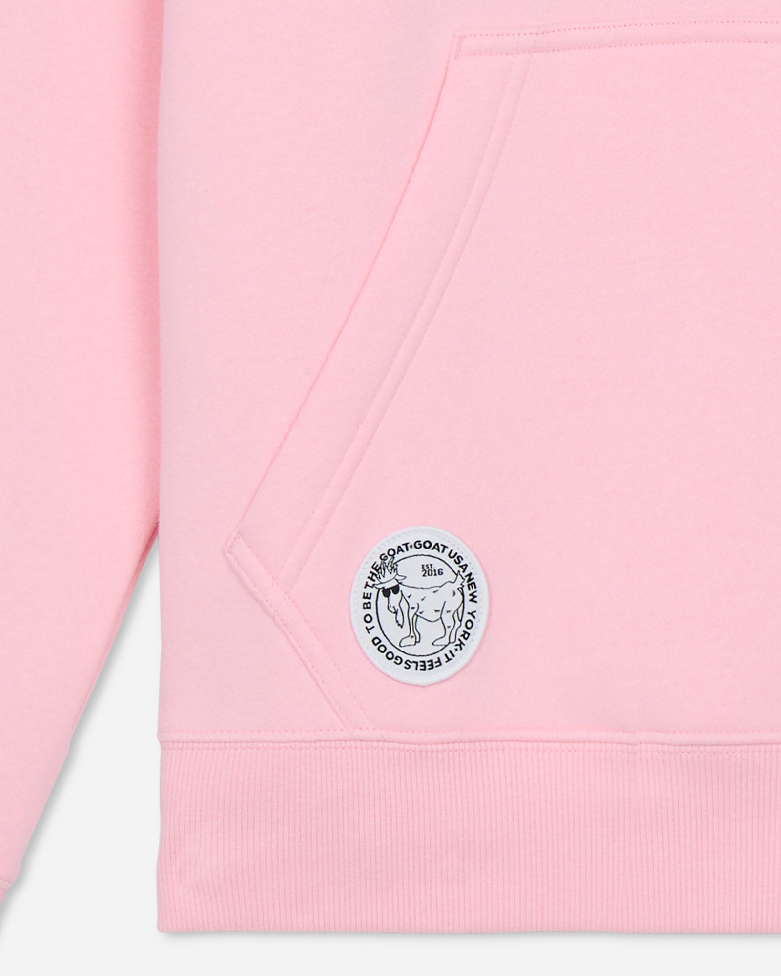 Pink hoodie with a logo patch on a light gray background
