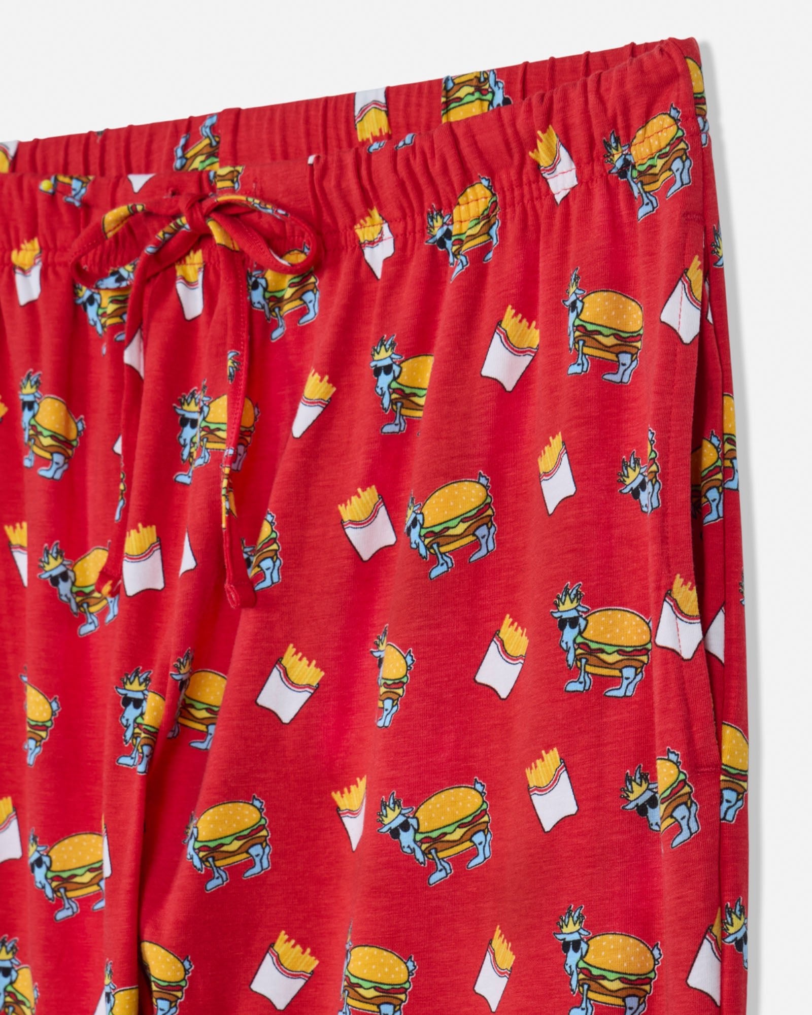 Red pajama pants with cartoon burger and fries pattern on a white background