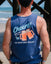 Man on the beach facing the boardwalk, photo is zoomed in on navy tank top