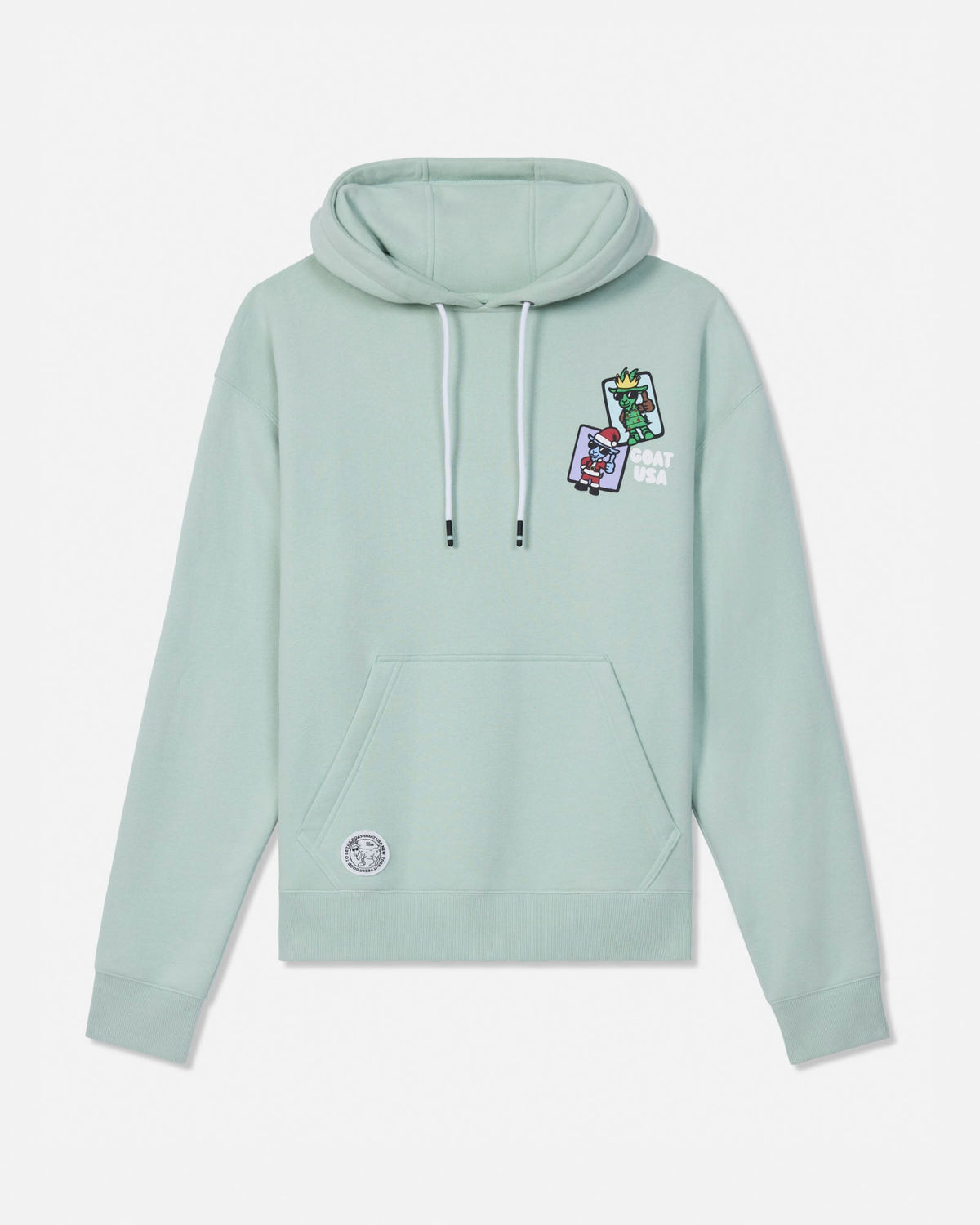 A sage green pullover hoodie with white drawstrings, featuring a small colorful graphic patch on the left chest and a circular patch on the lower left front pocket, displayed against a light gray background.