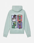 A mint green pullover hoodie shown from the back, featuring a colorful graphic print of four cartoon Christmas characters in separate panels with the text 'CHRISTMAS ESSENTIALS' and 'GOAT USA'.