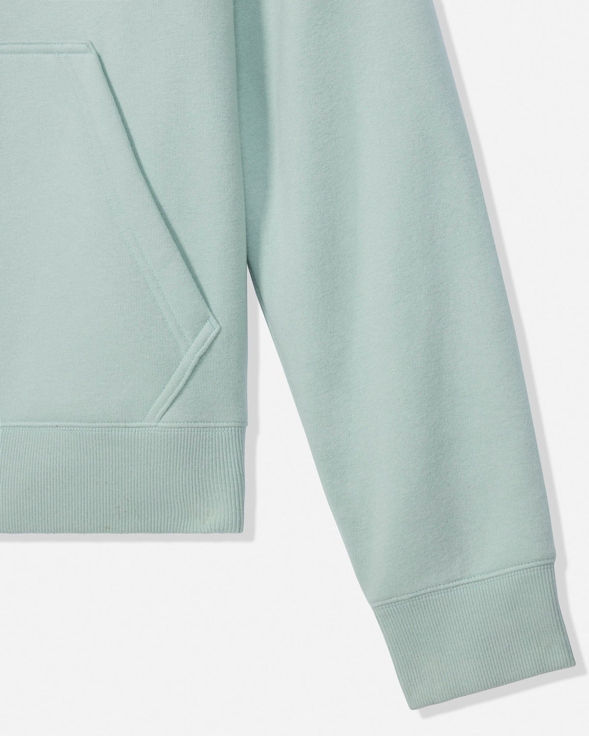 Close-up of a light mint green sweatshirt showing the sleeve, ribbed cuff, and part of the front pocket against a clean white background.