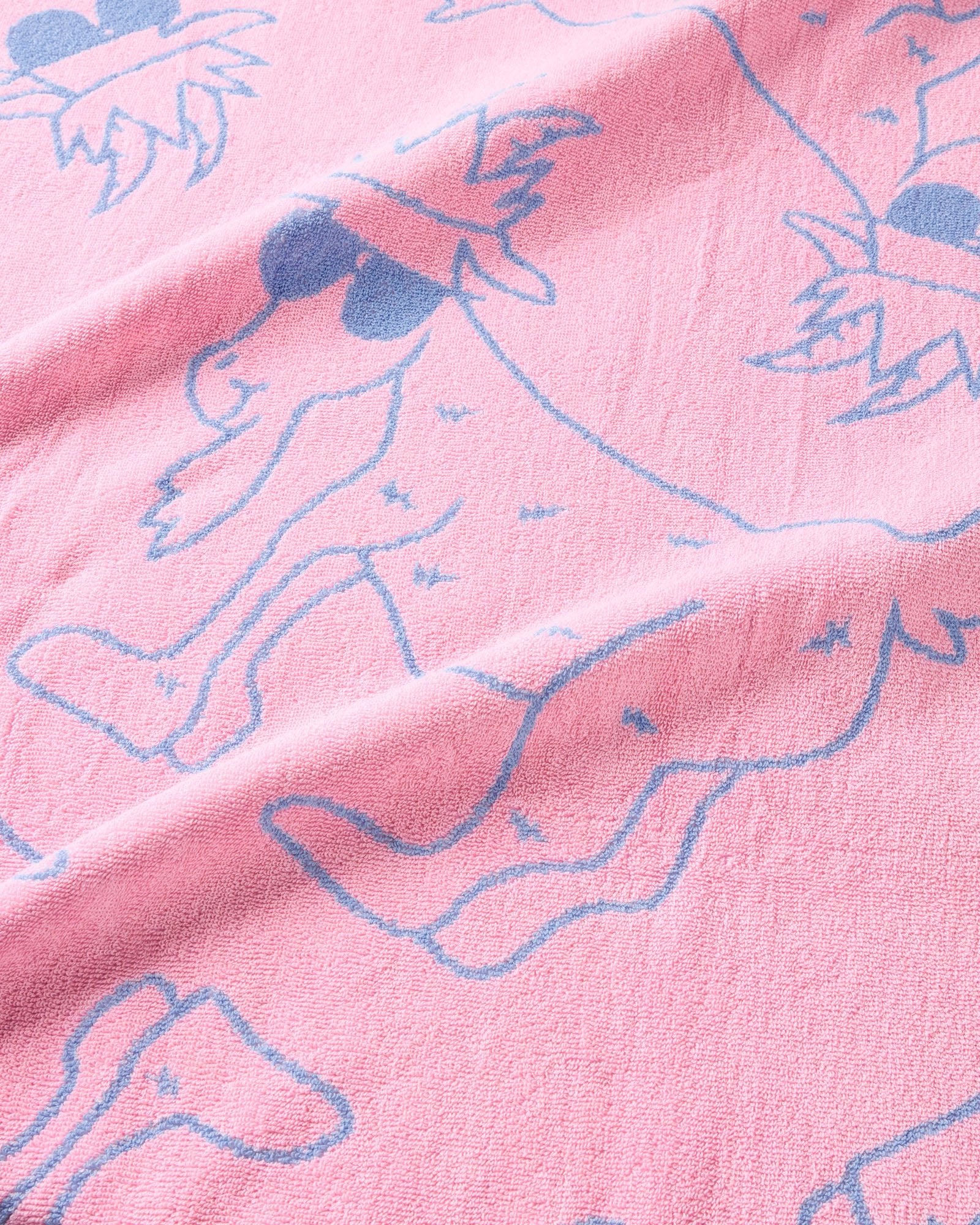 Close-up of pink fabric with blue outlines of goats.
