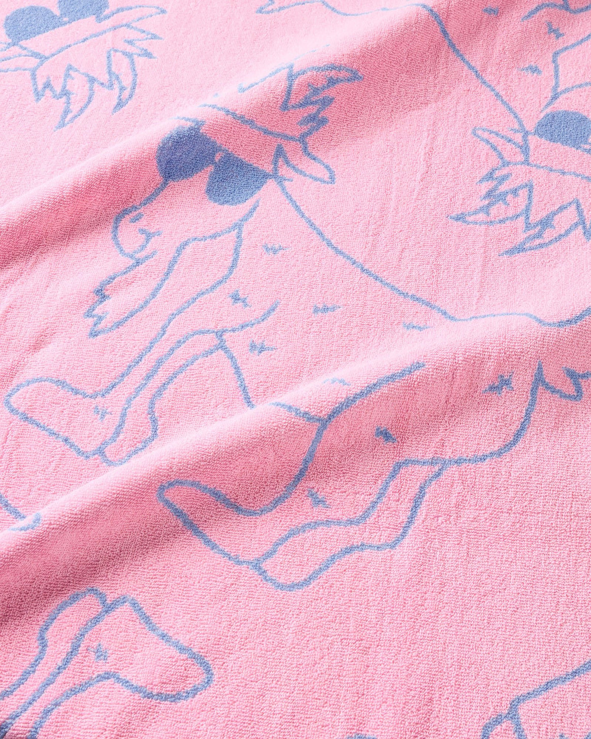 Close-up of pink fabric with blue outlines of goats.