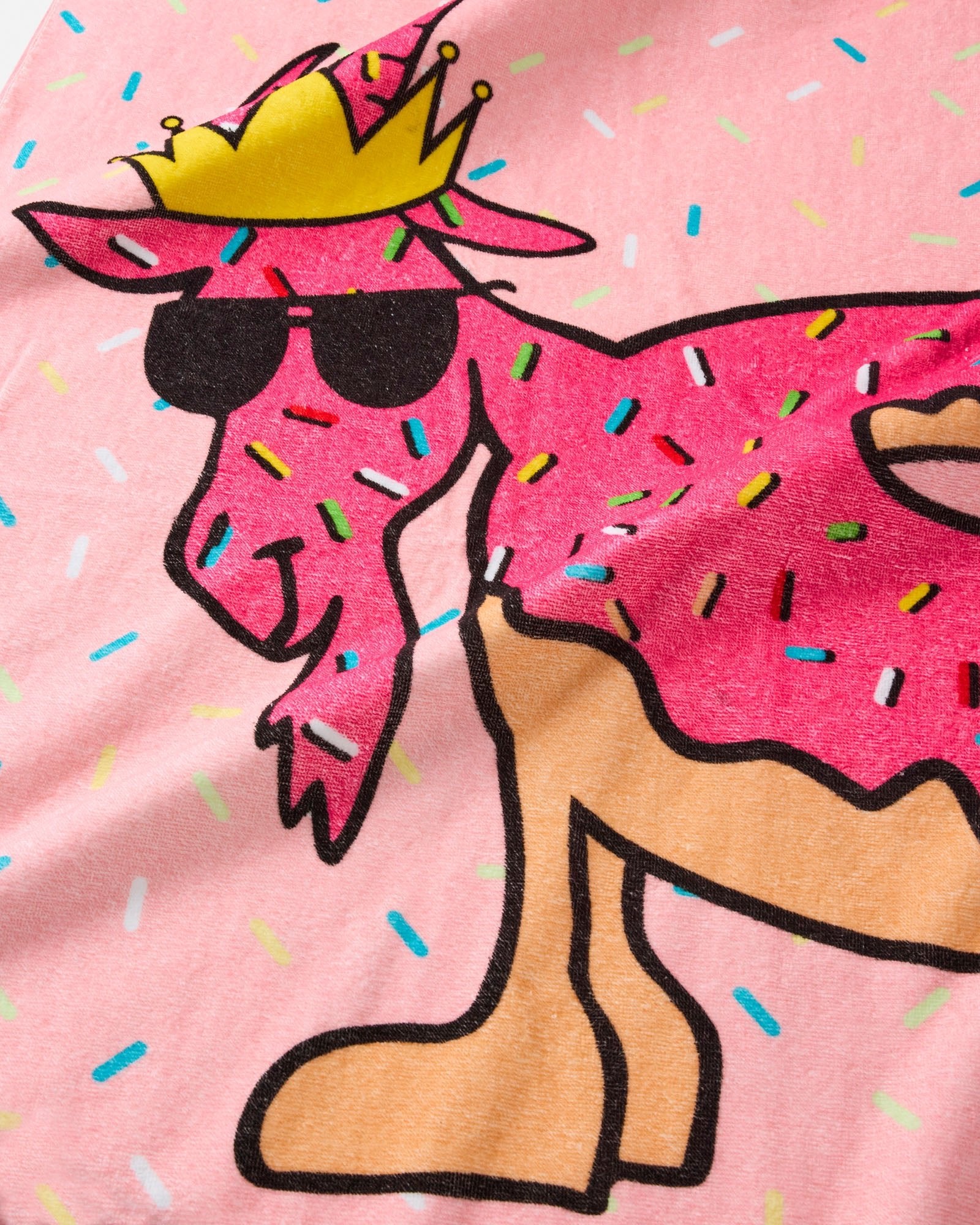 Donut with sunglasses and a crown on a pink background with sprinkles