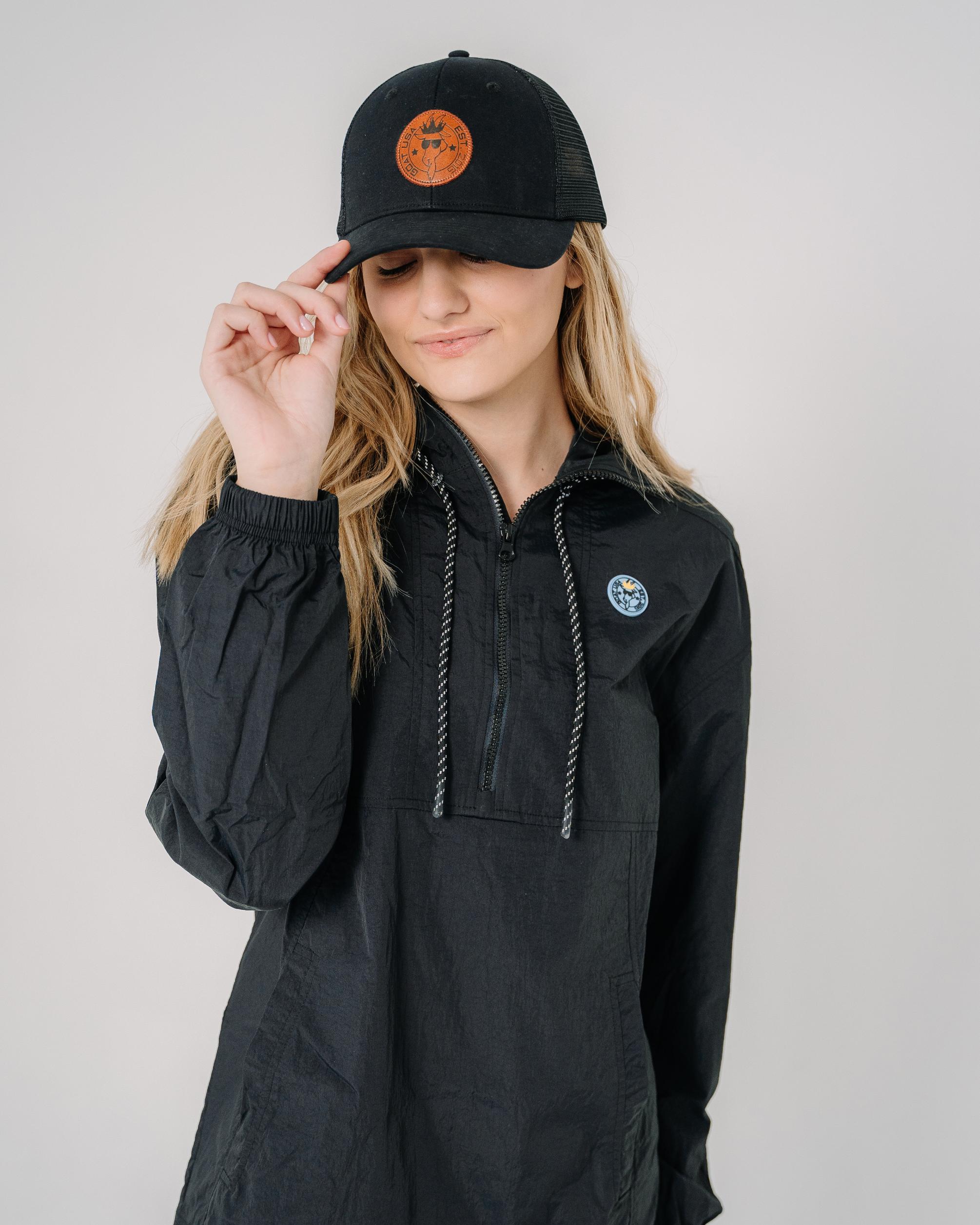 Girl wearing black hat with black mesh and brown leather patch#color_black