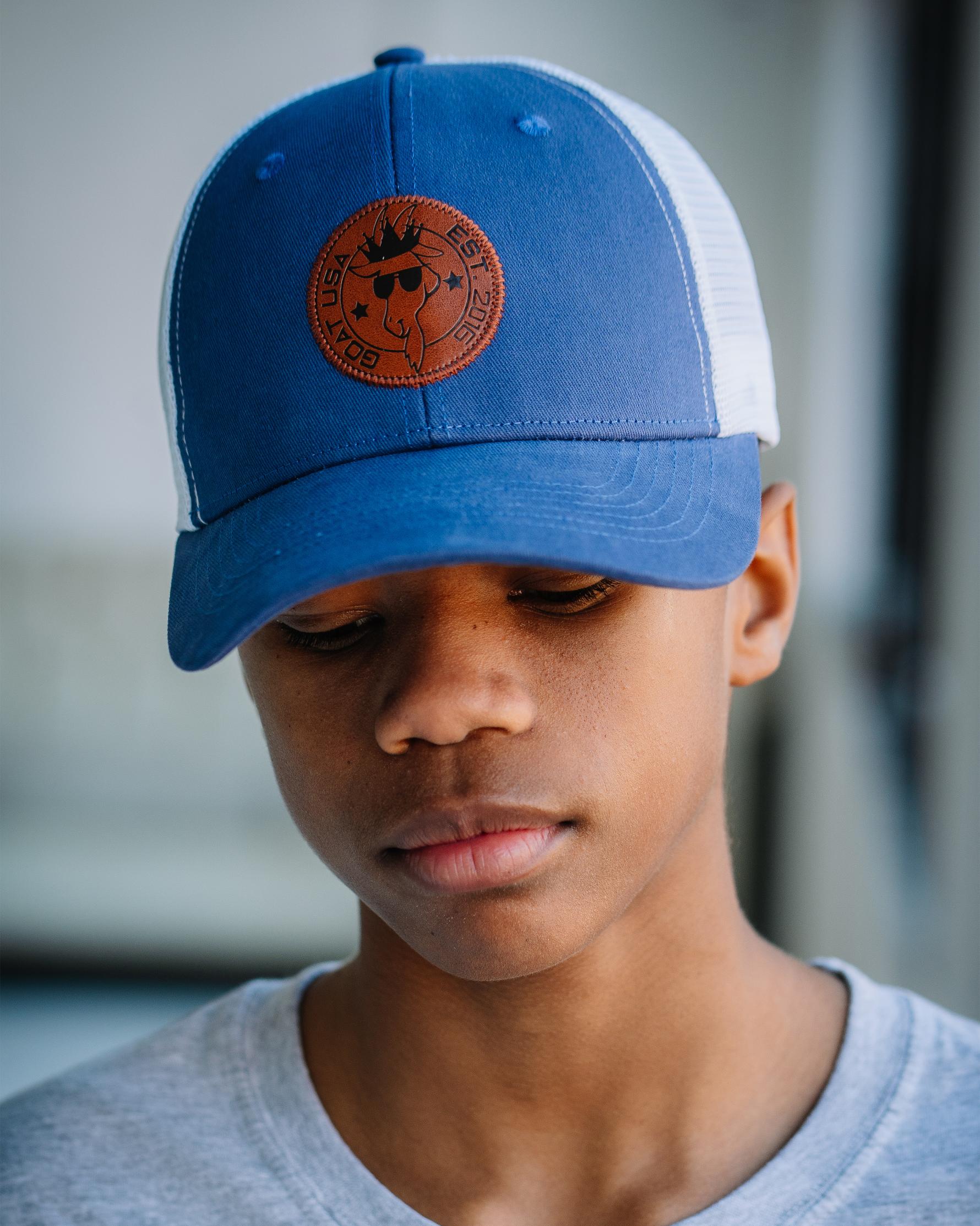 Boy wearing navy hat with white mesh and brown leather patch#color_navy