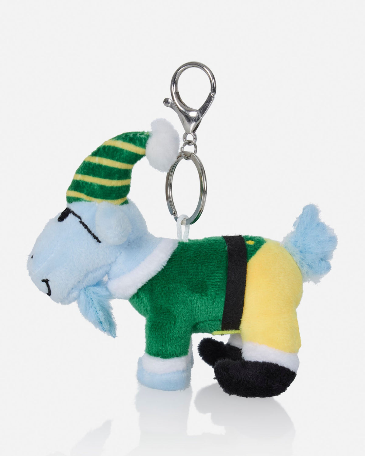 A plush goat keychain wearing a green and yellow striped elf hat, a green outfit, and yellow pants, attached to a silver metal clasp on a light gray background.