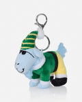 A plush goat keychain accessory featuring a light blue body, a green and yellow striped hat, a green outfit with yellow and black accents, and a silver metal clasp on a white background.