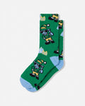 A pair of green crew socks featuring a pixel-art character pattern in yellow, blue, black, and white, with light blue heels and toes, displayed on a light gray background.