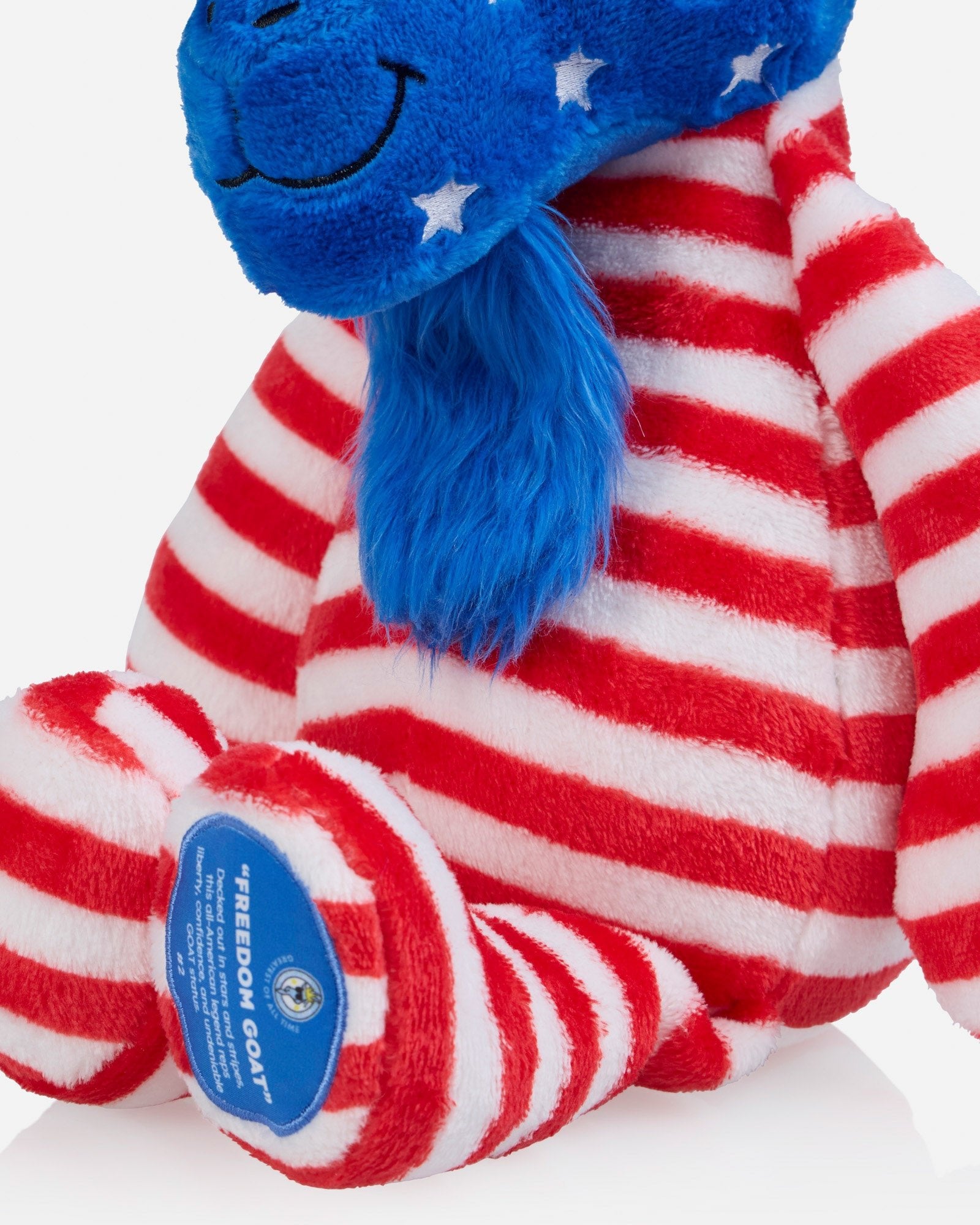 Plush toy with red, white, and blue stripes and a blue patch on a white background
