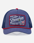 Blue trucker hat with 'Freedom' patch on a white background