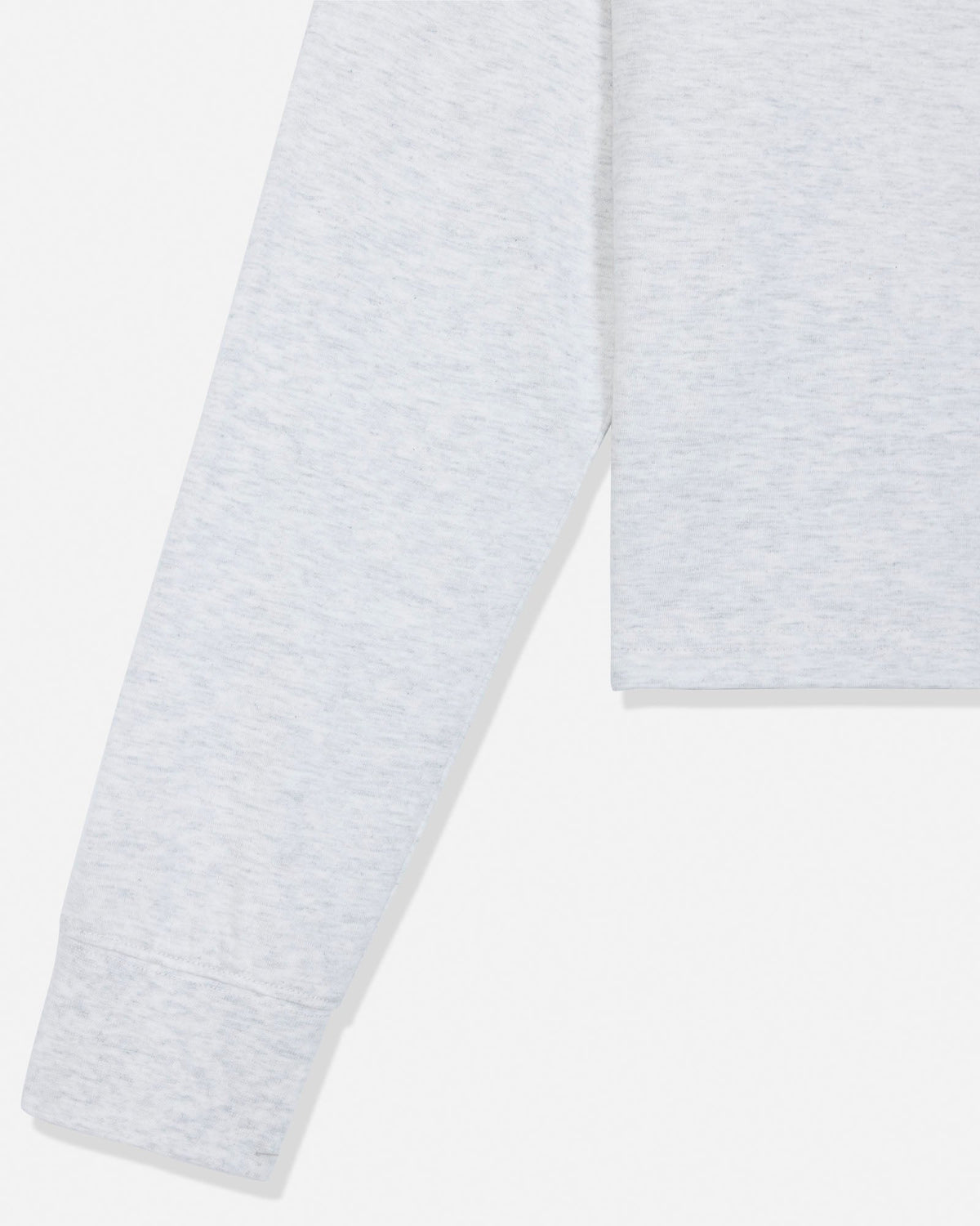 Close-up of a light heather gray garment, showing part of the sleeve and hem on a plain white background.
