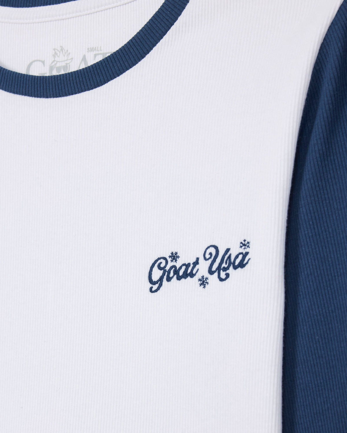 Close-up of a white and navy blue raglan-style shirt with 'Goat USA' embroidered in navy script on the chest.