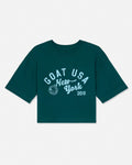 A dark teal green short-sleeve t-shirt with a white graphic print on the front reading 'GOAT USA New York 2016' and a circular crest, displayed flat against a light gray background.