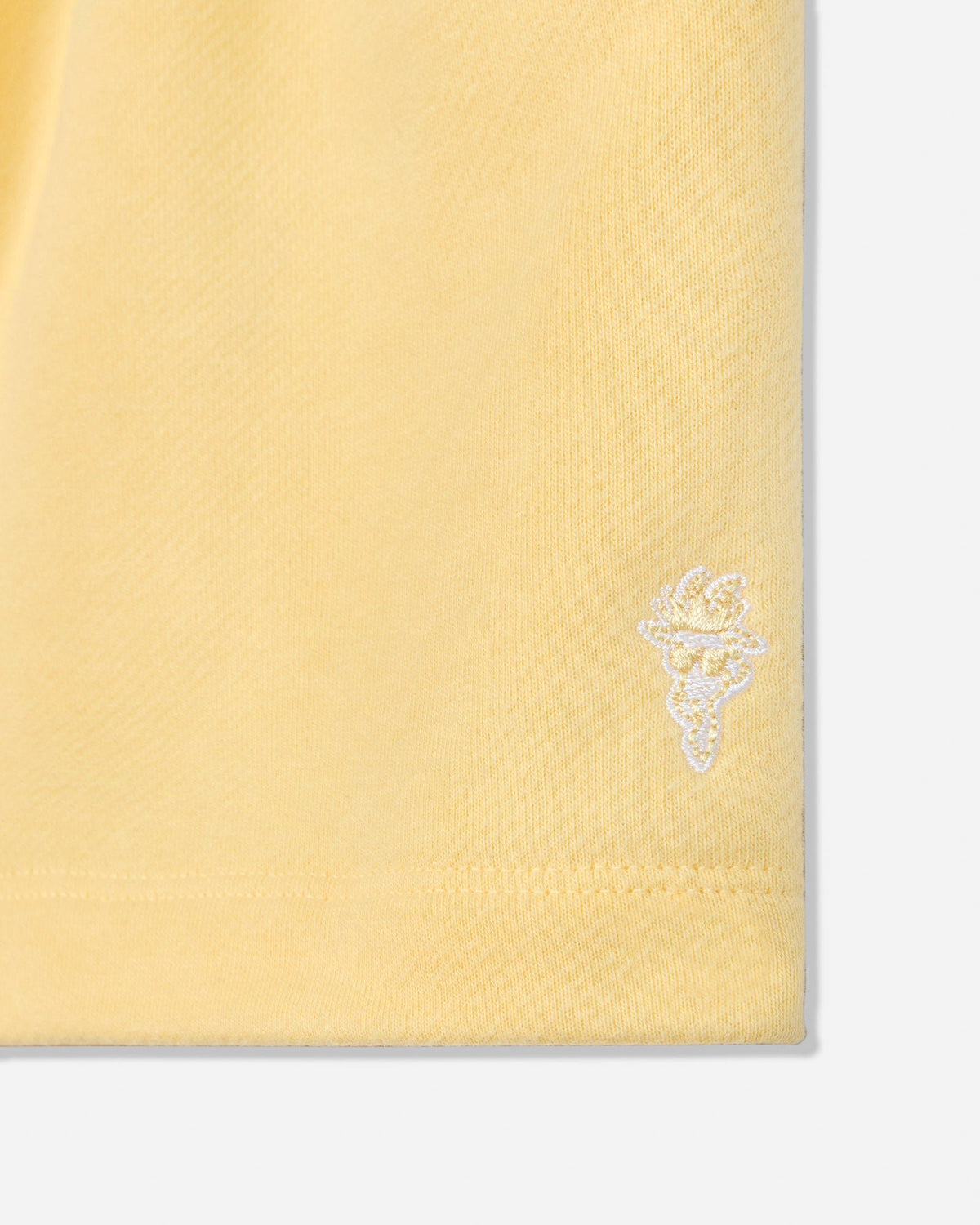 Close-up of corn milk sweat shorts goat head embroidery