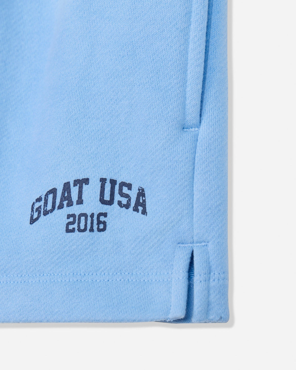 Close-up of carolina blue sweat shorts with 'GOAT USA 2016' text