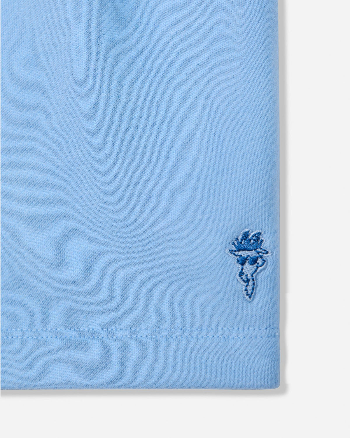 Close-up of carolina blue sweat shorts with goat head patch